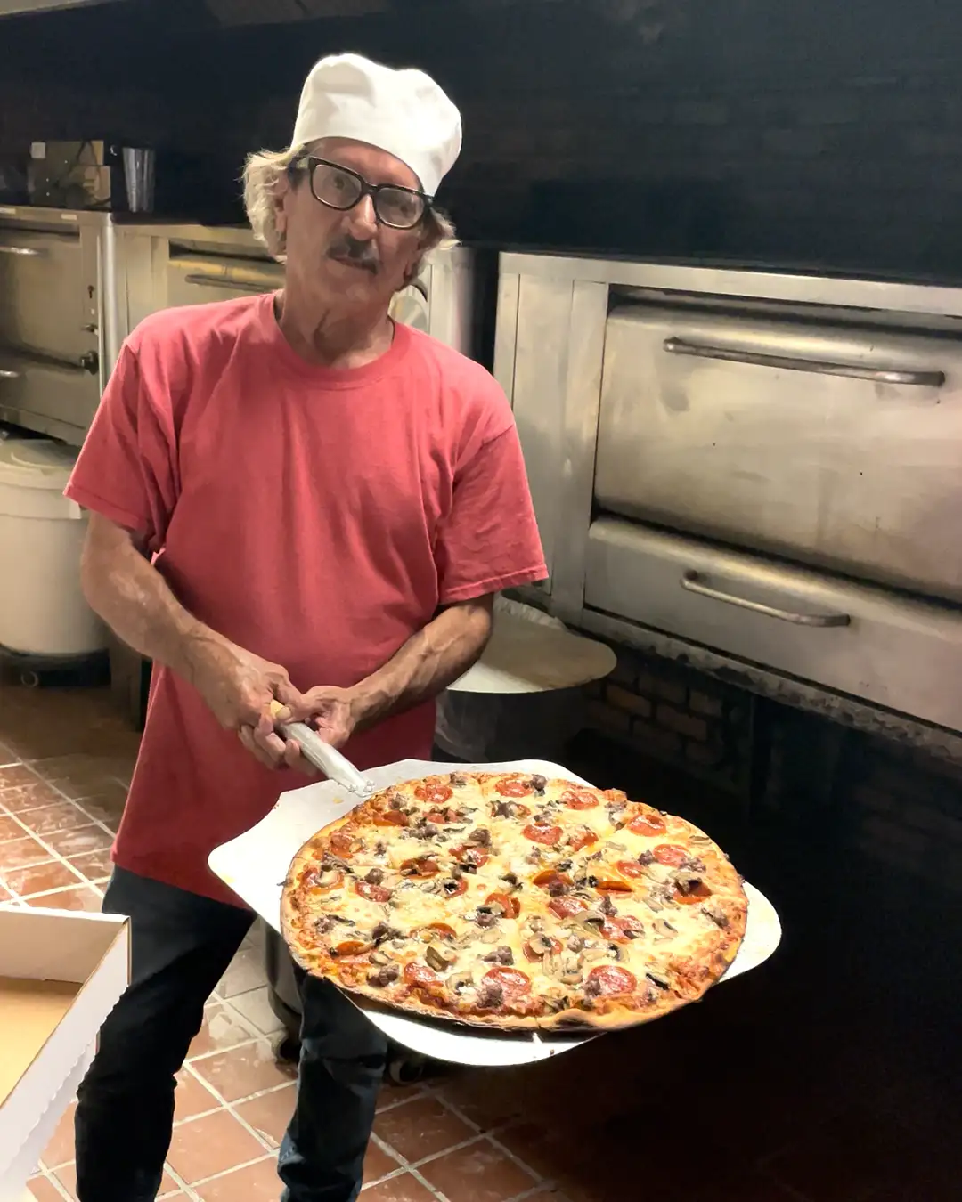 Villa Gargano owner John Gargano holds a pizza fresh from the oven.